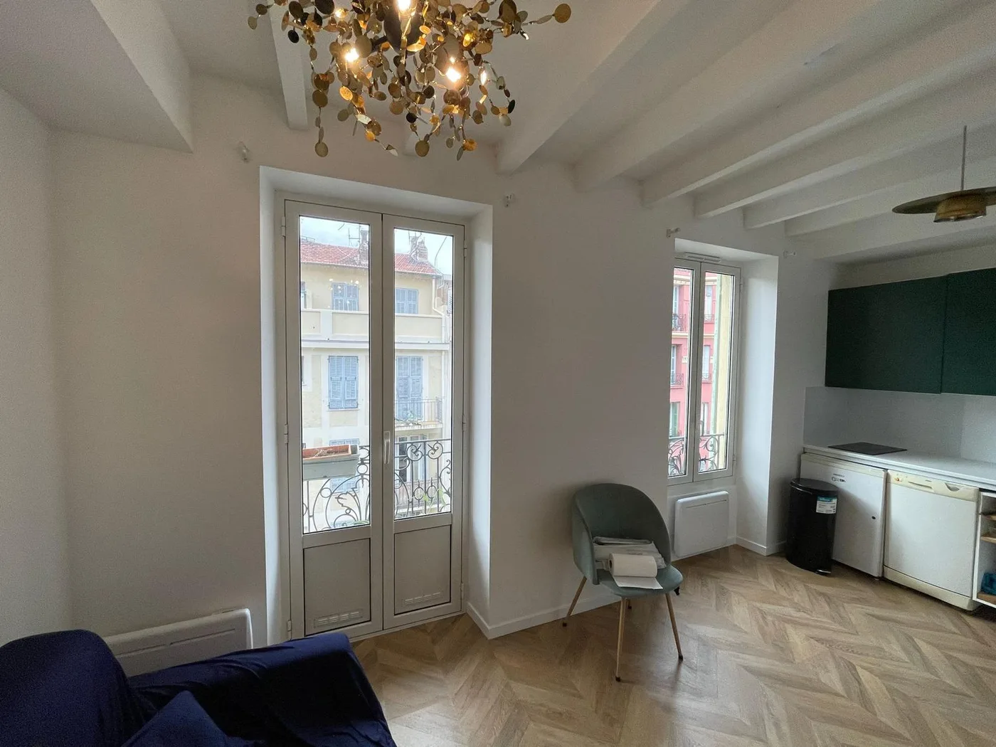 Séjour avec parquet chevron, moulures et vue sur la ville